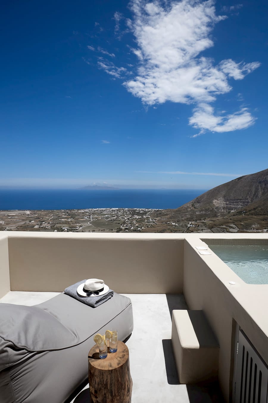 Private terrace with a heated jacuzzi and daybed above a sweeping Aegean sea view in Pyrgos, Santorini