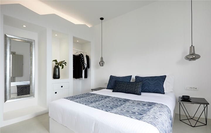 White Suite Two bedroom with a double bed, blue accents and a silver-framed mirror